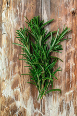 Fresh rosemary herb on a wooden background, vertical image. top view. place for text