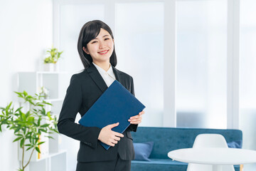 おしゃれなオフィスに立つスーツの女性