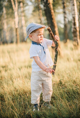 Portrait of a happy cute little boy having fun outdoors, exploring summer nature forest.