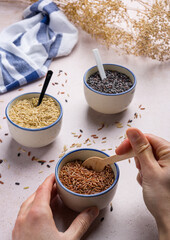 Scooping some red rice with a spoon from a bowl.