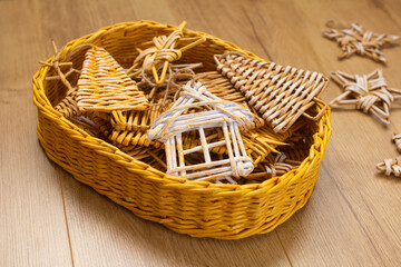 wicker Christmas decoration for a Christmas tree or at home stored in a wicker basket on a wooden background