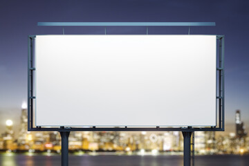 Blank white billboard on city buildings background at night, front view. Mockup, advertising concept