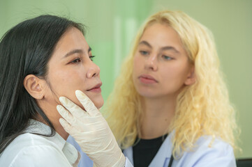 doctors examining patient face skin check before filler botox surgery. Beautician use hand glove touching woman face for diagnosis therapy skin care improvement.