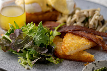 Mix dish Vegetarian breakfast salad with eggs Benedict, egg burrito, juice, toasted muffins, ham, poached eggs, and delicious buttery hollandaise sauce with fresh salad.