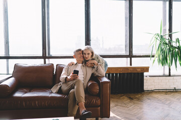 Obraz premium Happy couple with smartphone in living room