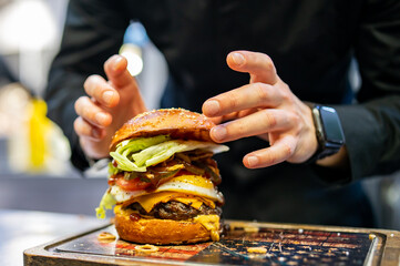 chef hand cooking cheeseburger on restaurant kitchen