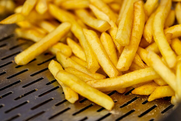 Potato chips fresh from deep dryer ready to be served in fast food restaurant.