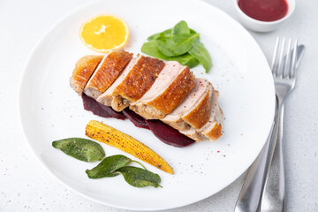 Files of the breast duck grill with beets, mini corn and spinach, fried sage, orange and lingonberry sauce. Traditional Mediterranean cuisine. Selective focus, close-up.