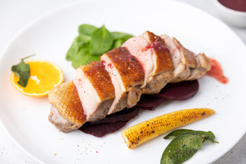 Files of the breast duck grill with beets, mini corn and spinach, fried sage, orange and lingonberry sauce. Traditional Mediterranean cuisine. Selective focus, close-up.