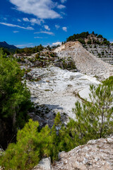 Fototapeta na wymiar Scenery panoramic view of white marble quarry, Thasos island, Greece. Sunny autumn day, mountain eaten by excavation 