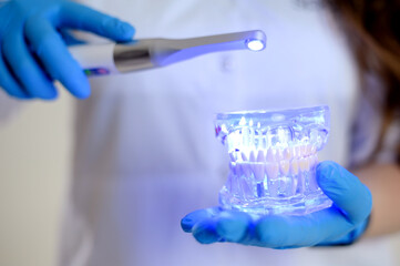 Photopolymer lamp Doctor Fairy with a glowing blue lamp in a white medical suit Dentist treatment...
