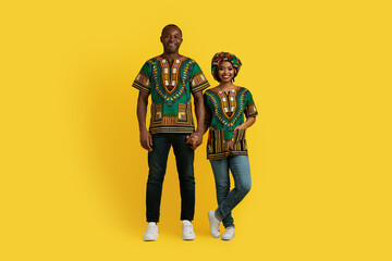 Happy traditional loving black couple posing on yellow