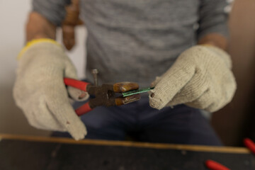 adult person with gloves and tool in hands