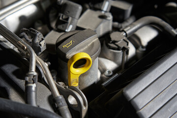 car engine oil filler and yellow dipstick for checking oil level