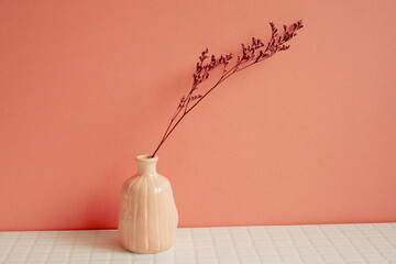 Vase of pink dry flower on white table. pink wall background. home decor