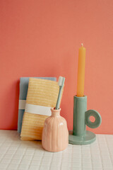 Bathroom shower towel and toothbrush, candle on white table. pink wall background