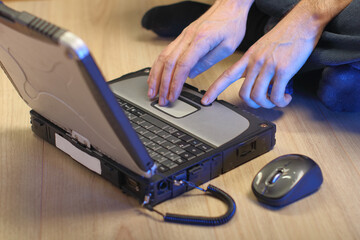 person typing on the keyboard of an old laptop