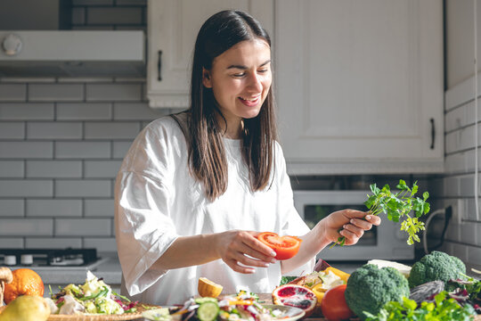 Attractive young woman with vegetables and fruits in the kitchen.