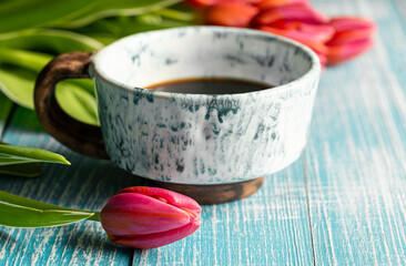 Spring composition with a cup of coffee and tulips.