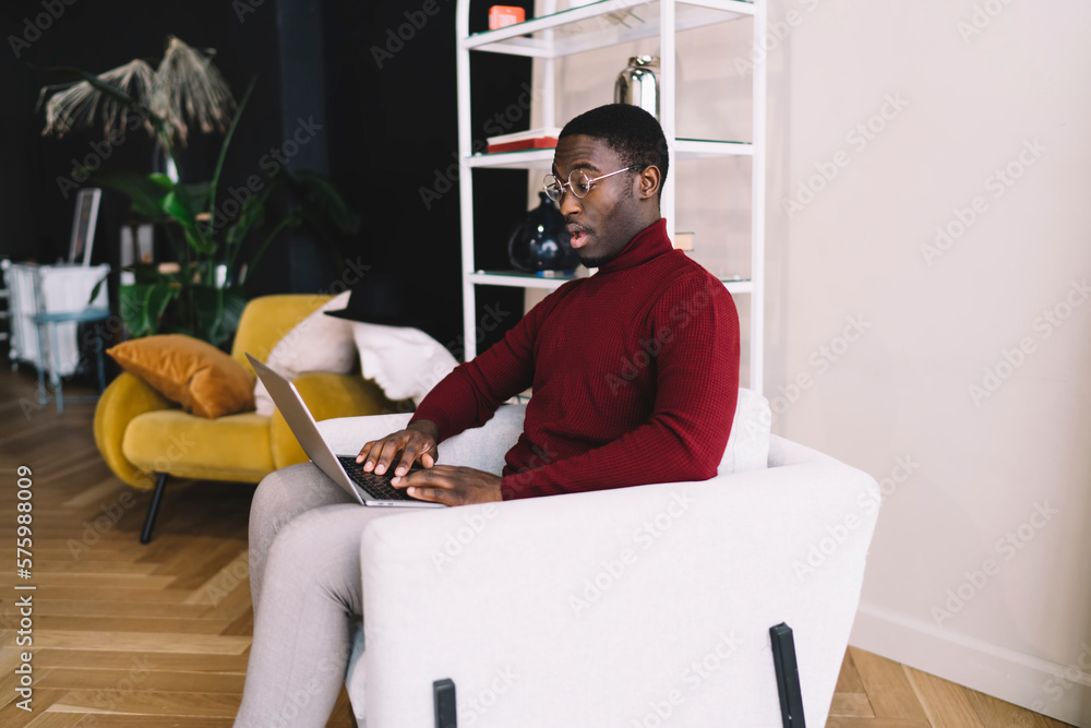 Poster surprised man using laptop while working