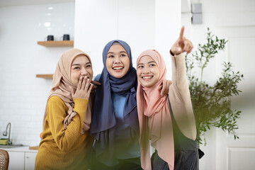 Group of Muslim girl friends express their excitement and surprise at their family's new home....