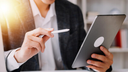 Financial analysts analyze business financial reports on a digital tablet planning investment project during a discussion at a meeting of corporate showing the results of their successful teamwork.