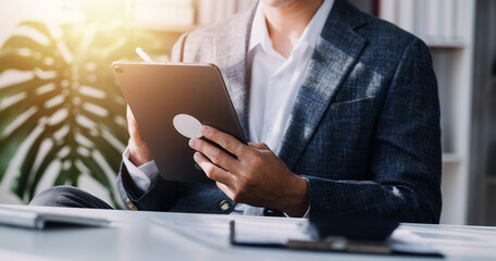 Financial analysts analyze business financial reports on a digital tablet planning investment project during a discussion at a meeting of corporate showing the results of their successful teamwork.