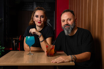 hombre barman con gorro de vaquero preparando un cóctel azul en la barra del bar