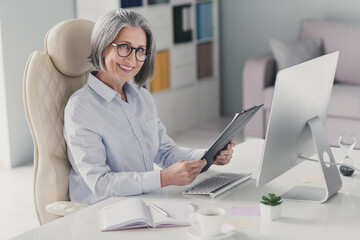 Profile photo of elegant successful positive lady sitting chair hands hold documents clipboard workplace indoors