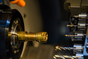 The  multi tasking CNC lathe machine  drilling the brass shaft parts.