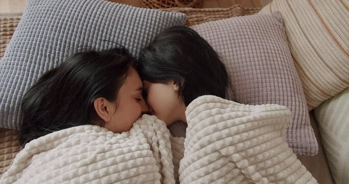 Couple of women hug each other warmly and relax at home in the bedroom. Lgbt and lesbian women at home. Embrace and holding each other, Romance and portrait of lesbian couple enjoying. LGBT rights.
