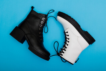 Stylish white and black women's shoes on a blue background. View from above.