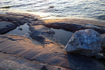 Evening sun coloring the smooth rock in the archipelago in summer