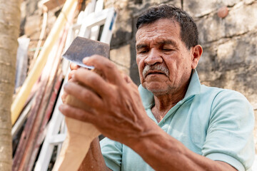 latino old man chopping wood medium shot