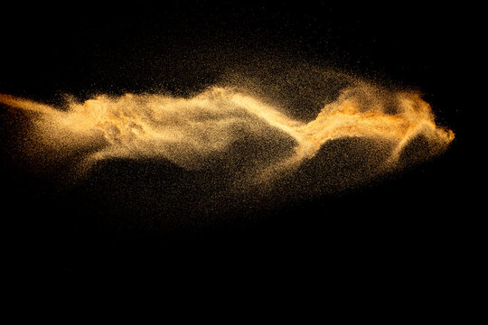 Dry river sand explosion.Brown color sand splash against black background.