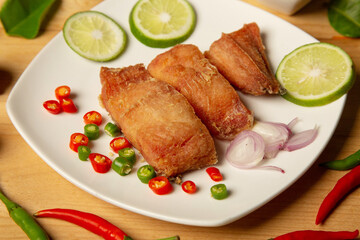  fried fish fillets served on white plate on old wooden top view, golden batter deep fried fish fillets,
lemon and orange slices, spices, concept - healthy seafood 
