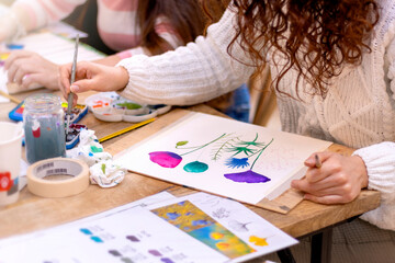 Watercolor Painting Workshop. Pretty female artist in the art studio and painting on paper.