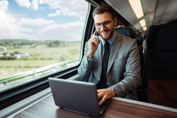 Handsome middle age businessman using his laptop computer while traveling with high-speed train....
