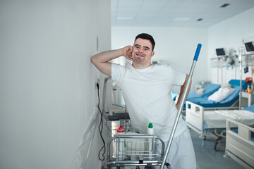 Young man with down syndrome working in a hospital as cleaner. Concpet of integration people with...