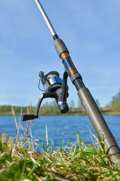 fishing rod, spinning reel. Close-up of fishing tackle. Spinning is installed on shore of reservoir