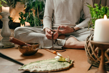 Close-up of unrecognizable man with rosary meditating with singing bowl and aroma stick - obrazy, fototapety, plakaty