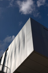 Bottom-up view of the corner of a modern building.