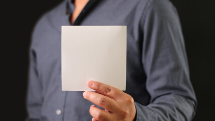 Man holding white blank square paper. Businessman show empty card