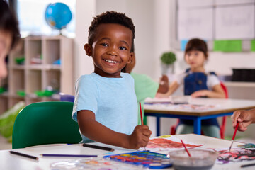Classroom Portrait Of Smiling Male Elementary School Pupil In Art Class At  School