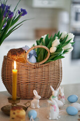easter cakes and rabbits on the background of basket with white tulips. Indoor, kitchen . High quality photo