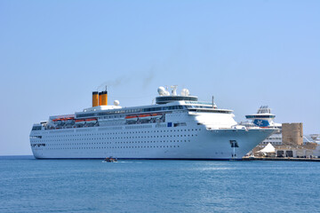 A cruise ship in a harbor with a boat isolated on the sea, close-up
