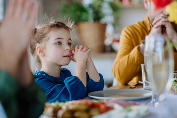 Close-up of family praying before Easter lunch.