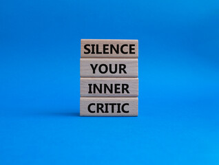 Silence your inner critic symbol. Wooden blocks with words Silence your inner critic. Beautiful blue background. Business and Silence your inner critic concept. Copy space.