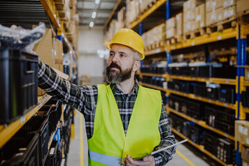 Warehouse worker checking up stuff in a warehouse.