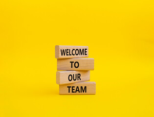 Welcome to our team symbol. Concept words Welcome to our team on wooden blocks. Beautiful yellow...